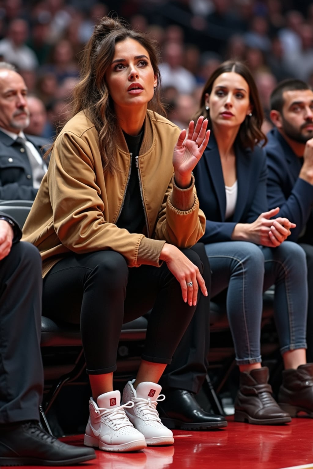 A celebrity attending a courtside NBA game, sitting in premium seats, clapping and reacting to an intense play. The woman is wearing a chic sporty outfit with a stylish bomber jacket and luxury sneakers . The electric atmosphere of the game is visible in the background.