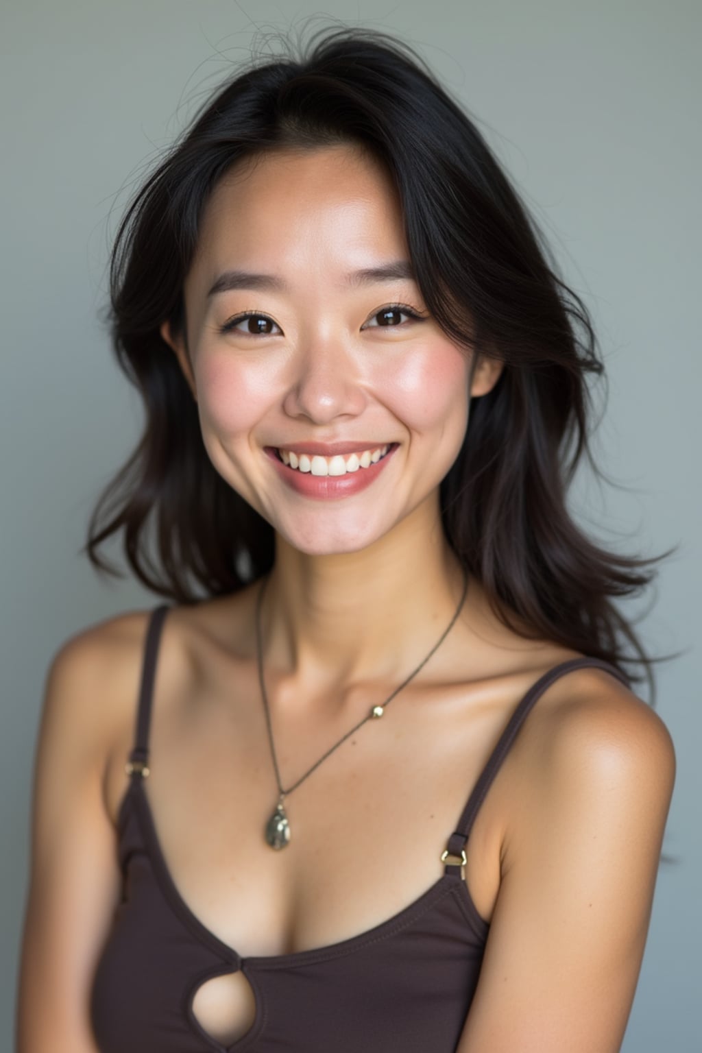 A professional comedian headshot taken in a well-lit studio with a clean, neutral backdrop. The woman is dressed in a stylish yet playful fitted top with natural makeup and a confident smile , ensuring a polished yet approachable look. The lighting is soft and even, highlighting the woman’s expressive face, charisma, and subtle comedic charm. The focus is sharp, capturing a warm and inviting expression, creating the perfect headshot for stand-up comedians, improv actors, and comedic performers.