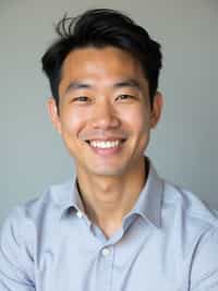 A professional therapist headshot of a compassionate man, taken in a well-lit studio with a plain backdrop. The man is dressed in  a neat, light-colored shirt with a friendly expression. The lighting is soft and even, highlighting their facial features with a warm and approachable expression. The focus is sharp, capturing the man's eyes and reassuring smile, creating a perfect headshot for therapy practices and professional profiles.