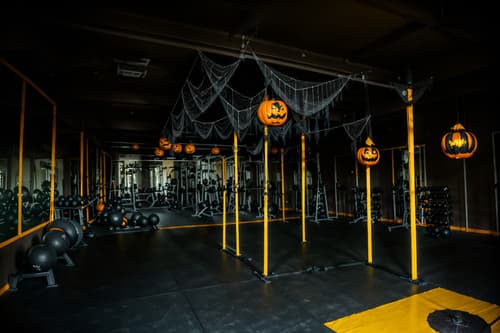 photo from pinterest of halloween-style interior designed (fitness gym interior) with dumbbell stand and crosstrainer and squat rack and bench press and exercise bicycle and dumbbell stand. . with yellow black balloons and lanterns and cobwebs and human skulls and skeletons sitting and standing and cobwebs and spiderwebs and glowing pumpkins. . cinematic photo, highly detailed, cinematic lighting, ultra-detailed, ultrarealistic, photorealism, 8k. trending on pinterest. halloween interior design style. masterpiece, cinematic light, ultrarealistic+, photorealistic+, 8k, raw photo, realistic, sharp focus on eyes, (symmetrical eyes), (intact eyes), hyperrealistic, highest quality, best quality, , highly detailed, masterpiece, best quality, extremely detailed 8k wallpaper, masterpiece, best quality, ultra-detailed, best shadow, detailed background, detailed face, detailed eyes, high contrast, best illumination, detailed face, dulux, caustic, dynamic angle, detailed glow. dramatic lighting. highly detailed, insanely detailed hair, symmetrical, intricate details, professionally retouched, 8k high definition. strong bokeh. award winning photo.
