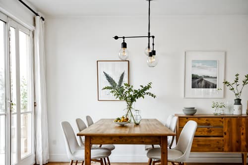 photo from pinterest of airbnb-style interior designed (dining room interior) with painting or photo on wall and light or chandelier and vase and dining table and plant and dining table chairs and table cloth and bookshelves. . with simple color palette and scandinavian style and simple, clean lines and simplistic furniture and natural materials and elements and open and natural lighting and neutral walls and textures and practicality and functionality and simple color palette. . cinematic photo, highly detailed, cinematic lighting, ultra-detailed, ultrarealistic, photorealism, 8k. trending on pinterest. airbnb interior design style. masterpiece, cinematic light, ultrarealistic+, photorealistic+, 8k, raw photo, realistic, sharp focus on eyes, (symmetrical eyes), (intact eyes), hyperrealistic, highest quality, best quality, , highly detailed, masterpiece, best quality, extremely detailed 8k wallpaper, masterpiece, best quality, ultra-detailed, best shadow, detailed background, detailed face, detailed eyes, high contrast, best illumination, detailed face, dulux, caustic, dynamic angle, detailed glow. dramatic lighting. highly detailed, insanely detailed hair, symmetrical, intricate details, professionally retouched, 8k high definition. strong bokeh. award winning photo.